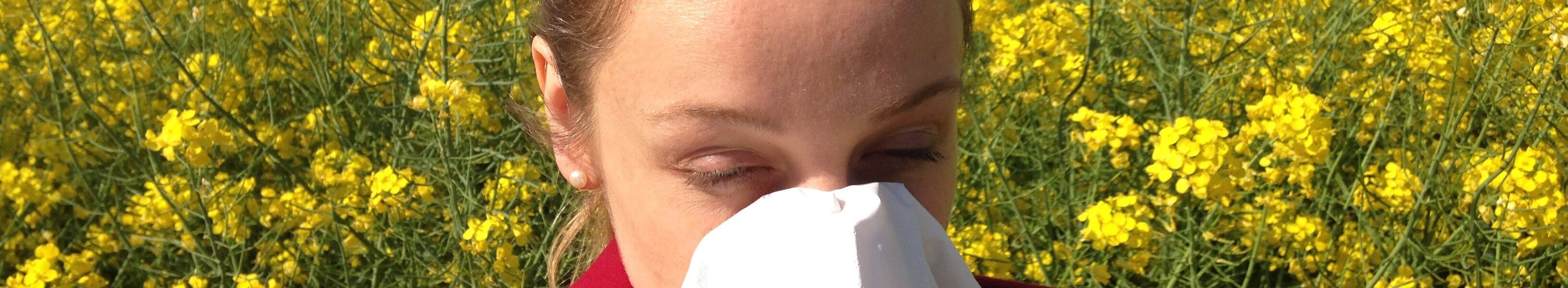 Nießende Frau vor einem Rapsfeld